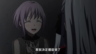 动漫《MyGO!》中的场景截图，画面中一位紫色短发的女性角色面带微笑，眼睛微眯，脸颊泛红，正在对画面右侧的另一位角色说话，台词为“那就決定選這張了”。背景为昏暗的室内环境，整体氛围温馨。