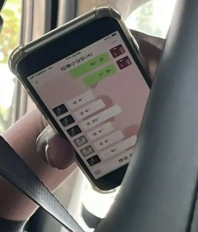 图中是一名司机或乘客在车内手持智能手机，正查看名为“拉猪小分队(4)”的微信群聊，并有多条语音消息未读。手机屏幕内容清晰可见，场景具有偷拍氛围。结合“拉猪小分队”这一调侃式群名及大量连续语音，透露出群聊高频沟通的无奈和搞笑，还可能暗示着该司机/乘客在摸鱼或被迫关注工作的场景。