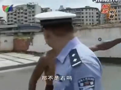 图片中一名身穿蓝色警服、头戴白色警帽的警察正在转头向左看，背景是城市建筑和一些旗帜。画面底部有字幕“那不是右吗”，显示警察正在质疑某个方向。整体场景看起来像是在户外的城市环境中，可能是在执行公务或处理某个情况时的瞬间抓拍。