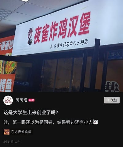 图片展示了某大学生活中心三楼一家名为'夜雀炸鸡汉堡'的店铺招牌，招牌为白色底，红色大字，左侧配有一个卡通小人形象。招牌下方是店铺的玻璃门入口。图片下方是社交媒体用户'阿阿塔'的发帖内容，用户配文'这是大学生出来创业了吗？哇，第一眼还以为是同名，结果旁边还有小人'，并提及'东方夜雀食堂'，暗示店铺名称和卡通形象可能让人联想到相关游戏梗。整体场景为校园内的商铺环境，带有明显的生活气息和网友的调侃意味。