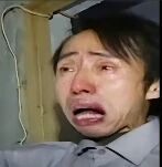 图片中是一名男子，他双眼通红，泪水正从眼角滑落，嘴巴大张，表情透露出极度的悲伤与崩溃。背景是一个光线昏暗的室内环境，隐约可见墙壁上悬挂的电线，整体氛围压抑。该图常被用作表达强烈负面情绪的表情包。