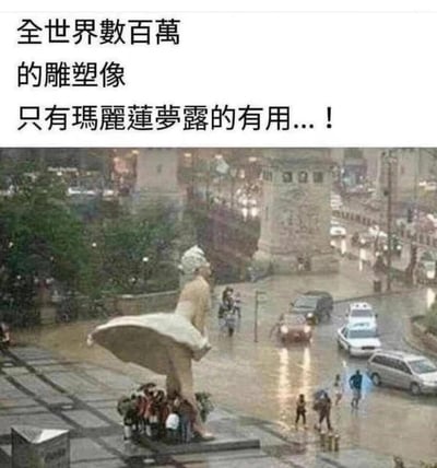 这是一张记录城市洪水场景的趣味照片，地面被浑浊的积水覆盖，车辆在积水中缓慢通行，行人在积水中艰难跋涉。画面前景是复刻玛丽莲·梦露经典掀裙造型的雕像，雕像宽大的裙摆下方聚集了一群躲雨避水的人。配文“全世界數百萬的雕塑像 只有瑪麗蓮夢露的有用...！”，巧妙利用雕像的造型特点，制造出“雕像裙摆成为临时避雨处”的趣味反差，让人忍俊不禁。