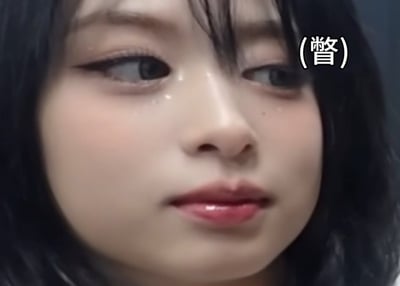 这是一张网络梗图，画面中凸显神秘气氛，主体为一名黑发人物，画面中央被大幅模糊遮挡处理，无法看清详细内容，右上角有括号括起的文字（部分已被遮挡），增添悬念感。常用于隐藏敏感信息或表达无言以对。