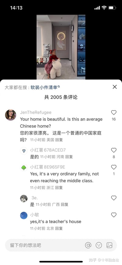 这是一张小红书的社交媒体截图，上方展示了一处装修精致的家庭走廊场景：一个扎着红头饰的小女孩赤脚骑在白色毛绒坐骑上，背景里有银色暴力熊潮玩、装饰画和带灯光的玻璃展示柜，柜内摆放着熊猫、天鹅等摆件，整体家装风格现代精致。下方是评论区，一位来自美国的网友留言询问“您的家很漂亮。这是一个普通的中国家庭吗？”，国内各地网友纷纷回复确认，还有浙江网友表示“这甚至没达到中产水平”，北京网友补充说明这是老师的家，引发关于中国普通家庭装修水平的讨论。