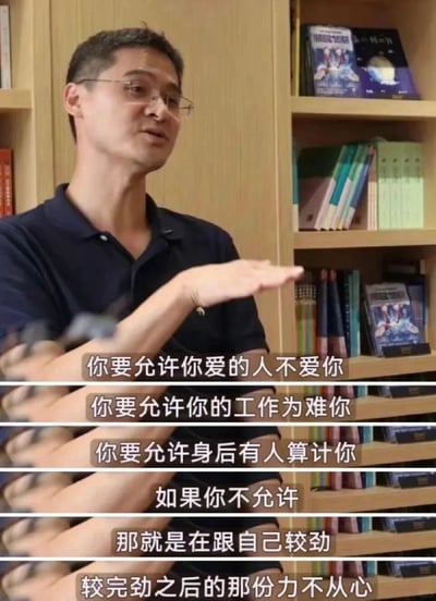 这是一张截取自媒体人罗翔公开演讲的视频截图，画面中罗翔身着深色POLO衫，身处摆满书籍的书架前，左手抬起平伸，正以手势辅助自己传递观点。画面下方配有六行字幕，内容围绕接纳生活中的不如意展开：引导人们允许爱人不爱自己、工作为难自己、他人算计自己，指出若无法接纳这些情况就是与自己较劲，最终只会陷入力不从心的状态，传递出通透豁达的人生态度，帮助观众调整心态，正视人生中的不完美与挫折。