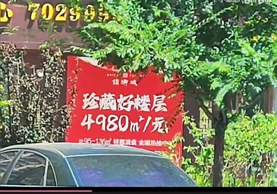 这是一张户外实拍的房产促销广告图，红色背景的广告牌上标注着「珍藏好楼层 4980㎡/元」，下方还有「95-136㎡ 特惠清盘 全城热抢中」的补充说明。显然是工作人员将房价单位写反，正确表述应为4980元/㎡，这个低级错误让广告看起来像是每元能购买4980平方米的房子，显得十分荒诞离谱。

笑点说明：广告将房价的单位「元/㎡」误写为「㎡/元」，形成了违背常识的价格表述，制造出滑稽的乌龙效果。