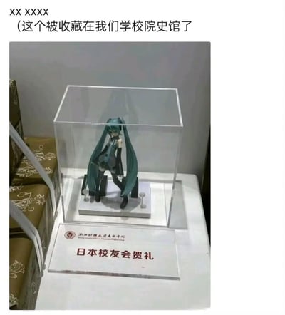 浙江财经大学东方学院的院史馆中，陈列着一件特别的展品——日本校友会赠送的初音未来手办。手办被安置在透明展示盒内，下方的展示牌标注着学校名称与「日本校友会贺礼」字样。顶部配文表示这件二次元手办已被学校院史馆收藏，这种二次元文化符号进入传统校史馆的组合，带来了有趣的反差感。