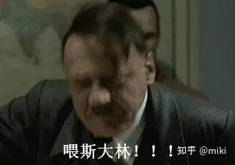 图片为电影《帝国的毁灭》中希特勒发怒场景的恶搞截图，画面中希特勒面露愤怒，身体前倾，下方配有恶搞字幕“喂斯大林！！！”，右下角带有“知乎@miki”水印。属于“元首之怒”系列鬼畜文化作品，通过添加虚构对话字幕对严肃历史场景进行娱乐化解构，以幽默方式呈现。
