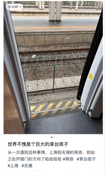 这张图片显示了一起高铁意外事件的现场情况。从高铁车厢内部向外拍摄，可以看到列车门打开后并未正对站台，而是朝向了铁轨一侧。图片中清晰可见铁轨、碎石道床以及带有铁丝网的防护栏，而非正常的站台区域。车门下方的黄黑相间警示条也清晰可见。图片下方配有文字说明："世界不愧是个巨大的草台班子 头一次遇到这种事情，上海到无锡的高铁，到站之后开错门的方向了哈哈哈 #高铁 #草台班子 #上海 #无锡"，表达了乘客对这一罕见失误的惊讶和调侃。