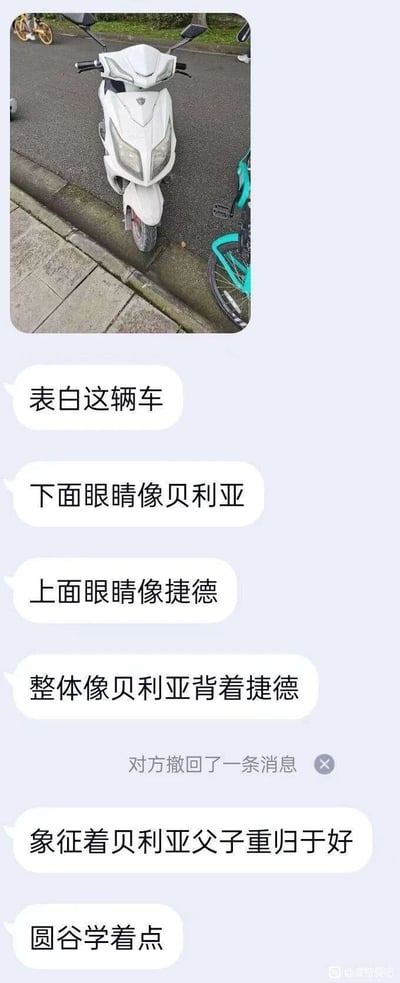 这是一张竖屏的聊天记录截图，顶部是一张白色电动车的实拍图，该车前脸设计有上下两组车灯。聊天内容中，发言网友对这辆电动车展开趣味调侃，称下方的车灯造型类似贝利亚奥特曼的眼部，上方的车灯类似捷德奥特曼的眼部，进而脑洞出“整体像贝利亚背着捷德”的有趣联想，还戏称这个造型象征着贝利亚与捷德这对奥特曼系列中的父子角色重归于好，最后还调侃圆谷制作公司可以参考这个设定，聊天过程中发言者撤回了一条消息，整体是结合经典特摄IP的生活化搞笑玩梗内容，充满趣味脑洞。