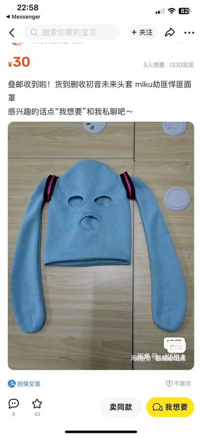 这是一张闲鱼平台的二手商品售卖截图，商品售价30元，是一款将虚拟偶像初音未来的标志性双马尾与悍匪三孔面罩结合的恶搞头套：整体为浅蓝色，保留了悍匪面罩的眼部、嘴部三孔设计，两侧延伸出类似初音未来双马尾的长条形结构，马尾根部还有模仿初音发带的黑粉配色装饰。页面显示该商品有5人想要、1330次浏览，卖家标注“叠邮收到啦！货到删收初音未来头套 miku劫匪悍匪面罩”，并引导感兴趣的用户点击“我想要”私聊，页面支持担保交易，底部配有互动、交易相关功能按钮。这款商品通过可爱虚拟偶像与硬核悍匪面罩的反差结合，打造出极具趣味的恶搞效果，面向ACG爱好者和喜欢趣味周边的人群。
