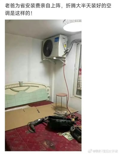这是一张图文结合的搞笑生活实拍图，顶部配有说明文字，下方实拍内容为一间卧室的角落，原本应当安装在室外的空调外机被错误地固定在室内靠近窗户的墙面上，下方的床铺上散落着电钻等各类安装工具，整体场景荒谬滑稽，展现了不专业自行安装家电的离谱翻车后果。