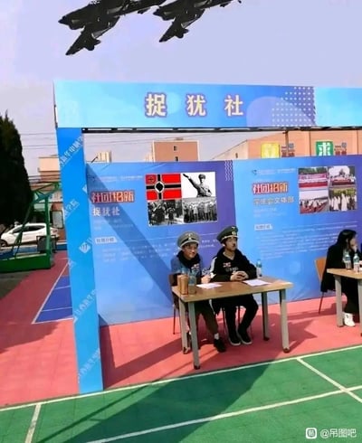 图片展示了一个校园社团招新摊位，摊位上方有