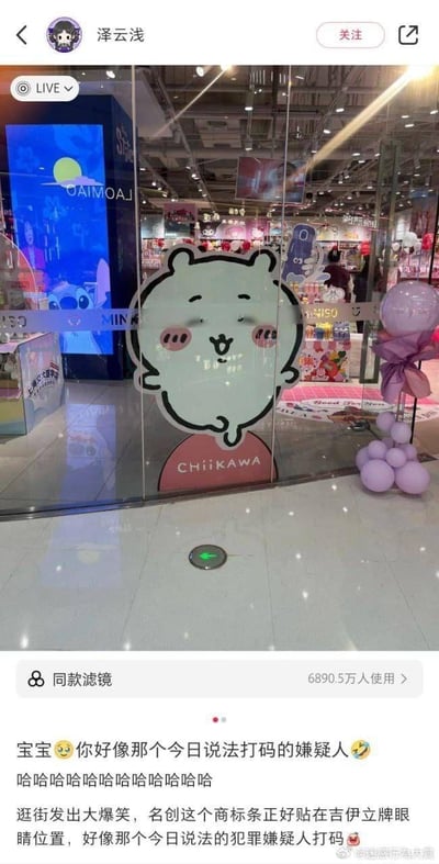 这是一张微博用户实拍的趣味场景图，地点为名创优品门店内，卡通角色吉伊（Chiikawa）的立牌被贴在玻璃门上，而名创优品的商标条恰好贴在立牌的眼睛位置，让原本可爱的吉伊看起来像《今日说法》节目中被打码的犯罪嫌疑人，形成了强烈的反差搞笑效果。博主逛街时发现这个巧合，拍下后配文调侃，引发爆笑。
梗点解析：利用视觉错位的巧合，将可爱的卡通角色与严肃法制节目里的打码嫌疑人形象结合，反差感拉满，制造出荒诞的搞笑效果。
