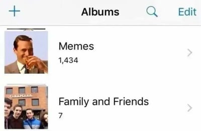这是一张手机相册的界面截图，页面顶部显示“Albums”（相册）标题，下方展示了两个相册条目。第一个相册标注为“Memes”（梗图），封面是电影《楚门的世界》中主角楚门举杯的经典画面，该相册内共有1434张图片；第二个相册标注为“Family and Friends”（家人和朋友），封面是一张多人户外合照，相册内仅有7张图片。两者的图片数量形成了极其鲜明的反差，以此调侃当代年轻人在网络环境中热衷于收集和保存梗图，而与家人朋友相关的照片却寥寥无几，凸显出梗图文化在年轻人日常网络生活中的高占比，以及一种略带自嘲的生活状态，容易引发有类似情况的网友共鸣。