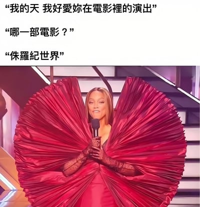 图片上半部分是三段对话文字："我的天 我好愛妳在電影裡的演出"、"哪一部電影？"、"侏羅紀世界"。下半部分是美国超模泰雅·班克斯穿着一件夸张的红色扇形礼服，手持麦克风站在舞台上的照片。图片通过将泰雅·班克斯的造型与《侏罗纪世界》电影联系起来，制造出幽默效果，暗示她的礼服造型像恐龙。