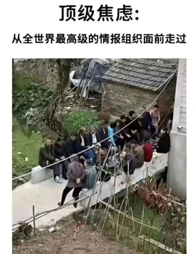 图片上方有文字“顶级焦虑：从全世界最顶级的情报组织面前走过”，下半部分是一张俯拍农村场景的照片。一群中老年人在村口聚集，似乎在热烈讨论什么，表现出典型的“广场八卦”氛围。画面营造出一种“如果你从旁边经过会很紧张”的幽默效果，将村中长辈们的“情报传播能力”夸张到‘世界顶级情报组织’级别。富有生活气息和乡村幽默感。无明显谐音梗，但有双关和夸张比喻。