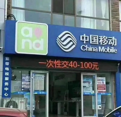 这是一张线下中国移动宽带电视服务中心门店的实拍图，门店门头的LED滚动显示屏上写着“一次性交40-100元”的字样。
这句话原本是指宽带或话费的预缴费用，但字面表述存在歧义，容易让人产生不当联想，从而形成了搞笑的梗点，被网友当作趣味内容传播。