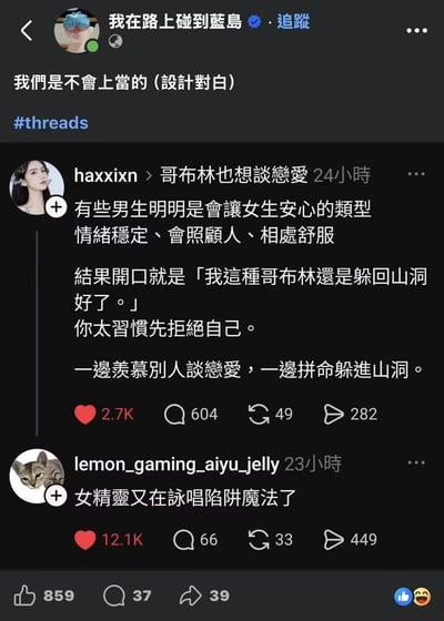 这是一张Threads社交平台的深色模式界面截图，最上方用户「我在路上碰到蓝岛」发布内容称「我们是不会上当的（设计对白）」，附带#threads标签。下方引用了用户haxxixn的发帖，内容感慨部分本身条件不错、能让女生感到安心的男生，会自我贬低为哥布林要躲回山洞，习惯先否定自己，处于一边羡慕他人恋爱、一边刻意回避亲密关系的状态，该帖获2.7K点赞。更下方的用户评论用玩梗的方式调侃原帖内容是「女精灵又在咏唱陷阱魔法了」，该评论获得12.1K点赞，热度高于原帖，最上层的转发帖共获得859个点赞。
