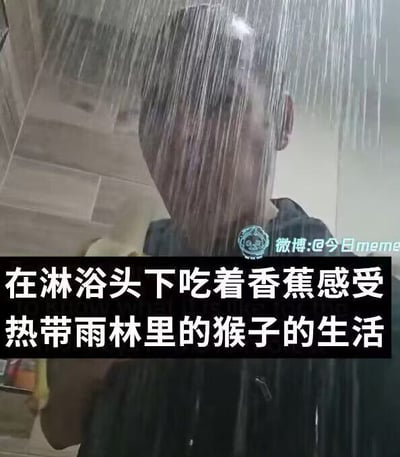 图中一名真人站在淋浴头下，水流从头顶倾泻而下，手中拿着香蕉正在食用。底部有文字叠加：“在淋浴头下吃着香蕉感受热带雨林里的猴子的生活”，通过将淋浴水比作雨林雨水、吃香蕉的行为类比猴子，以幽默方式营造出模仿雨林猴子生活的滑稽场景，整体风格轻松搞笑。