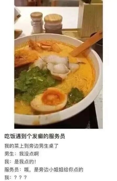 这是一张图文结合的搞笑内容，上方为实拍的餐厅场景图，画面主体是一碗配料丰富的日式拉面，包含溏心蛋、绿色叶菜、鱼片、虾等食材，碗中放有木勺，背景可见桌面摆放的调味瓶等餐厅常见陈设；下方配文讲述了一段令人啼笑皆非的就餐乌龙事件：当事人点的餐品被服务员错端到邻座男性顾客的桌上，男性顾客表示自己没有点这道菜，当事人出声说明是自己点的，服务员却误以为是当事人特意给该男性点的餐，这番话让当事人十分错愕。