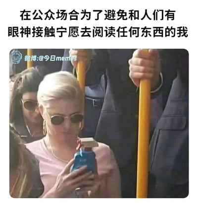 这是一张在拥挤的公共交通工具（地铁）内拍摄的梗图，画面中一位戴墨镜的金发女士，为了避免和周围拥挤的人群产生眼神接触，特意将一个类似儿童饮料盒的物品举到面前，做出专注阅读的姿态。图片上方配有文字“在公众场合为了避免和人们有眼神接触宁愿去阅读任何东西的我”，精准地调侃了社恐人群在公共场合中，为了回避社交尴尬而做出的滑稽行为，引发同类人群的共鸣。