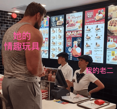 这是一张在麦当劳餐厅拍摄的照片，照片中一名肌肉发达的男子穿着背心正在柜台前点餐，两名麦当劳员工站在柜台后。图片上有两处中文文字覆盖：男子背上写着粉色的"她的情趣玩具"，女员工附近写着"我的老二"，形成了一个低俗的对比笑话。