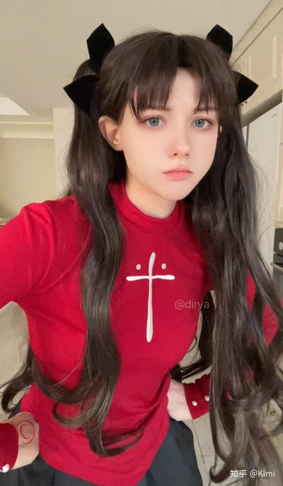 一位穿着红色十字T恤的少女，留着双马尾发型并佩戴黑色蝴蝶结。她站在室内环境中，表情严肃地看向镜头。背景似乎是厨房或类似的生活空间。