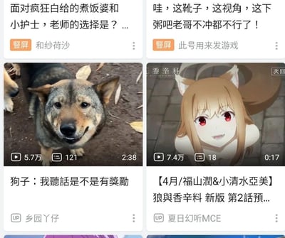 这是一张哔哩哔哩（B站）移动端首页的推荐视频栏截图，展示了四个竖屏推荐视频卡片：
1. 左上是游戏类视频《面对疯狂白给的煮饭婆和小护士，老师的选择是？...》，主打游戏角色相关内容；
2. 右上是游戏向视频《哇，这靴子，这视角，这下粥吧老哥不冲都不行了！》，标题带有网络热词，偏向吸引游戏爱好者；
3. 左下是宠物视频《狗子：我聽話是不是有獎勵》，画面里的土狗面带讨喜的微笑，看起来乖巧听话，播放量5.7万；
4. 右下是4月新番《狼与香辛料》新版的第2话预告，角色是经典的贤狼赫萝，由福山润、小清水亚美配音，播放量7.4万。
整体是B站算法推送的多元内容推荐，涵盖游戏、宠物、ACG动漫品类。