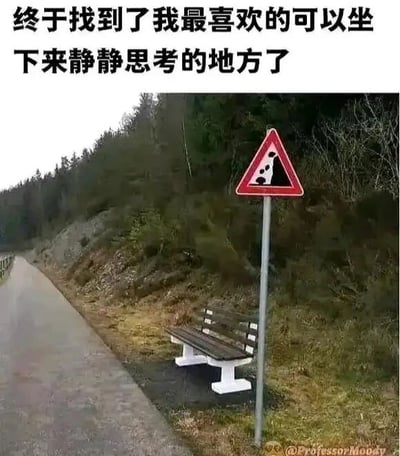 这是一张带有搞笑创意的实拍照片，画面展示了一条郊外小路的场景：小路旁的坡地上放置着一张白支架棕椅面的长椅，紧邻长椅的位置立着一个红边三角形的落石警示交通标志，标志上的黑色落石图案恰好和下方的长椅在视觉上重合，看起来就像是标志里的“人形图案”坐在了长椅上。图片上方配有中文文字“终于找到了我最喜欢的可以坐下来静静思考的地方了”，利用这个巧妙的视觉巧合，将警示标志的图案和真实长椅结合，营造出仿佛这里就是专门为静坐思考设置的地点的幽默效果，属于利用视觉错位制造趣味的梗图。