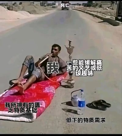 这是一张文字加注的真人实拍静态图，画面中一名男子坐在道路中间的红色薄垫子上，正吸食着水烟，他的身旁仅有水瓶、小容器和拖鞋这类简陋物品，道路远处还有一辆行驶的车辆。图片通过文字标注将各个元素赋予了象征意义：把道路远处的车辆标注为“死亡”，男子标注为“我”，手中的水烟标注为“一些能缓解痛苦的文艺或低级趣味”，身下的垫子标注为“我所拥有的匮乏物质基础”，身边的简单物品标注为“低下的物质需求”，以此自嘲式地表达自身在物质匮乏的生活里，依靠简单消遣来麻痹自己、面对生活的状态，充满了无奈又戏谑的情绪。