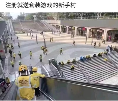 这是一张现实场景的实拍照片，拍摄地点为一个城市商圈的公共区域，画面中分布着大量外卖骑手，其中多数穿着美团的黄色统一制服，还有少量其他平台的外卖员。这些外卖员的状态各不相同，有的正乘坐自动扶梯上行，有的在广场的地面区域行走穿梭，有的则坐在台阶上休息停留。画面上方配有文字“注册就送套装游戏的新手村”，用游戏里新手村注册就送初始套装的设定做比喻，调侃外卖行业新人入行即可获得统一的工作制服，如同游戏新手获得初始装备，而这个聚集了大量外卖员的区域，就像游戏里新手起步的新手村一样，充满了刚入行或等待派单的从业者，用幽默的方式展现了外卖行业的从业现状。