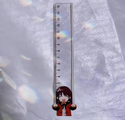 这是一款兼具实用性与收藏性的二次元主题亚克力直尺，尺子最大量程为15厘米，刻度清晰准确。直尺底部设计了一个Q版深棕发二次元角色，她穿着红黑配色的外套，头顶有爱心发饰，表情开心兴奋，双手握住直尺的两侧，仿佛正举着尺子，造型十分可爱。背景是带有梦幻光斑的银色纹理布料，更凸显出周边的精致感，适合学生日常使用，也可作为二次元爱好者的收藏摆件。