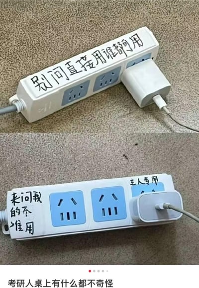 两张上下对比的插线板照片，展现了考研人桌上的幽默场景。上图插线板贴着「别问直接用谁都可用」的手写纸条，下图同款插线板却写着「来问我的不准用」和「主人专用」，形成有趣反差。底部配文「考研人桌上有什么都不奇怪」点出主题，用日常生活小物件调侃考研学生的学习状态。
