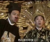 图片中展示了两位身着古装的人物，左侧人物头戴黑色官帽，身穿深色官服；右侧人物头戴金色皇冠，身着华丽的金色龙纹服饰。两人表情均显惊讶，背景为金色的宫殿装饰。画面底部有白色文字“他还要你梦里”，整体呈现出古装剧中的对话场景。