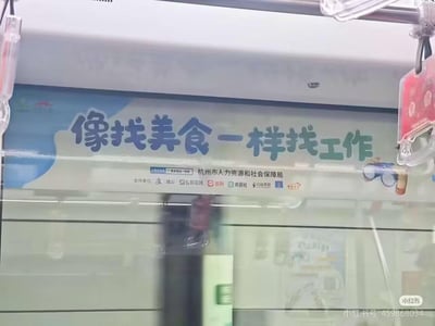 地铁车厢内的一则求职宣传广告，主视觉文字为“像找美食一样找工作”，采用生活化比喻降低求职焦虑感。广告主体为蓝白配色，上方有云朵装饰图案，下方标注发布单位“杭州市人力资源和社会保障局”及支付宝、前程无忧、猎聘等多家合作机构Logo。背景可见地铁车窗玻璃反射及模糊的车厢内部结构，整体氛围贴近日常通勤场景。
