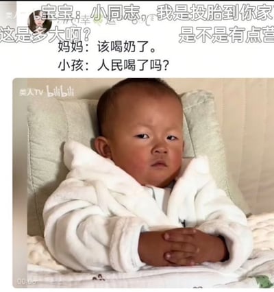 这是一张带文字配文的视频截图。画面主体是一名短发、肤色偏深的婴儿，他穿着白色毛绒浴袍，靠在浅灰色软垫上，双手交叠放在身前，表情严肃、眼神凝重，呈现出与年龄不符的“小大人”感。上方文字写着“宝宝：小同志，我是投胎到你家……”，中间的段子对话为“妈妈：该喝奶了。小孩：人民喝了吗？”。笑点在于婴儿成熟严肃的神态与孩童身份形成反差，并把普通的喝奶提醒变成一本正经的夸张反问。画面上方两侧还有被裁切的评论句“这是多大啊？”“是不是有点营……”，无法看到完整内容。