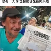 图中有两位流浪汉模样的真人，左侧男子戴着黑色帽子，眼含热泪面露激动神情，右侧男子手持一份经过修改的报纸，报纸头版印着两人的照片与外文报道文字。图片顶部配有中文文字“总有一天，你也会出现在新闻头版”。这是通过P图的方式，实现了“登上头版”的“梦想”，用幽默戏谑的方式调侃普通人的“成名”幻想，带有自嘲和搞笑的意味，同时也透出一丝小人物对“被关注”的戏谑式期待。
