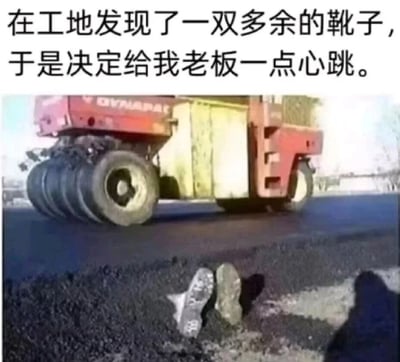 这是一张充满整蛊趣味的工地场景图片，上方配有文字“在工地发现了一双多余的靴子，于是决定给我老板一点心跳。”。画面展示了正在铺设沥青的工地，一台红色压路机正在新铺的沥青路面作业，在画面下方的沥青边缘处，埋着一双靴子，仅露出靴筒部分，视觉上营造出有人不慎被压路机碾入沥青中的惊悚假象，这是工地员工利用多余的靴子设计的恶作剧，目的是吓唬老板，制造出紧张又搞笑的效果。
