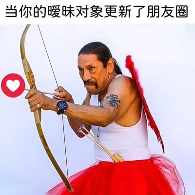 图片展示了一位肌肉发达的男子，留着长发和胡子，左臂有纹身，戴着手表。他穿着白色背心和红色芭蕾舞裙，背后插着红色羽毛翅膀，正专注地拉弓瞄准一个红色的心形图标（类似社交媒体点赞按钮）。图片上方配有文字'当你的暧昧对象更新了朋友圈'，通过硬汉形象与丘比特元素（弓箭、翅膀）的反差，幽默地表现出人们看到暧昧对象更新社交媒体时的急切关注心态。