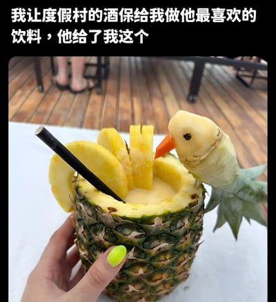 图片上方配有文字‘我让度假村的酒保给我做他最喜欢的饮料，他给了我这个’，下方是一只手（涂着亮黄色指甲油）拿着一个用整个菠萝掏空制成的杯子，杯中装有淡黄色饮品，插入黑色吸管，杯口装饰有切片菠萝和用菠萝果肉雕刻成的小鸟造型，整体呈现出度假村特色的创意饮品样貌，充满夏日度假氛围。
