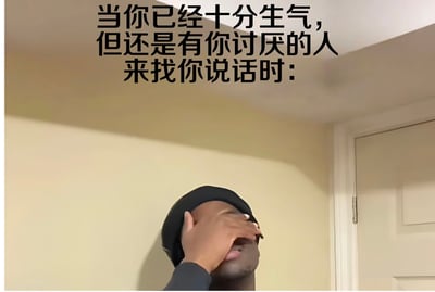 图片上方有一行黑色文字：'当你已经十分生气，但还是有你讨厌的人来找你说话时：'。图片下方是一位戴着黑色帽子的黑人男子，他用右手捂住眼睛和额头，表情看起来非常无奈和疲惫，似乎在强压怒火。背景是一个室内场景，有米色的墙壁和白色的门框。