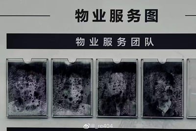 这是一块标注着“物业服务图”的展示板，下方“物业服务团队”区域的员工照片展示框被布满水汽和污渍的玻璃完全覆盖，原本的员工照片只能透出模糊的人影轮廓，看起来像抽象的泡沫水墨效果。这种“自己的展示板都没维护好”的情况，和“物业服务”的主题形成强烈反差，充满了讽刺感，让人觉得搞笑又无奈，调侃了物业服务不到位的现状。