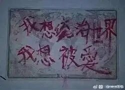 这是一张横版的手写涂鸦类标语图，以偏灰暗的平整表面为底色，用红色的笔手写了两行文字：“我想统治世界”与“我想被愛”，文字带着随性的手写质感，右下角带有微博用户“@我的微胖”的水印。两行文字呈现出强烈的反差感，前者是充满野心、极具强势感的宏大诉求，后者是柔软细腻、渴望被关怀的情感需求，精准地展现出个体内心深处矛盾又真实的双重诉求，既有对外掌控的欲望，又有对内被接纳被爱的渴望。