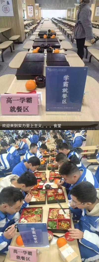 这是一张上下拼接的对比实拍图，上图展示了学校食堂内布置好的「高一学霸就餐区」，长桌上整齐摆放着精致餐盒、水果与餐具，食堂其余区域空旷；下图则是同一区域，身着蓝白校服的高一学生们正低头专注享用丰盛的套餐。图中配文「欢迎来到实力至上主义。。。食堂」，调侃学校为学霸设置专属就餐区域的安排，类似“实力至上”的校园设定，引发对校园差异化对待的讨论。