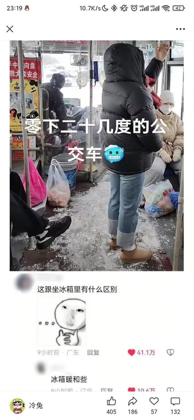 图片展示了一辆在极寒天气下的公交车内部场景，一名穿着黑色羽绒服的乘客正站立扶着扶手。车内地面上有积雪，乘客们都穿着厚重冬装。图片上方配有文字"零下二十几度的公交车🥶"，下方有网友评论"这跟坐冰箱里有什么区别"和"冰箱暖和些"，用幽默方式吐槽极端寒冷的乘车体验。