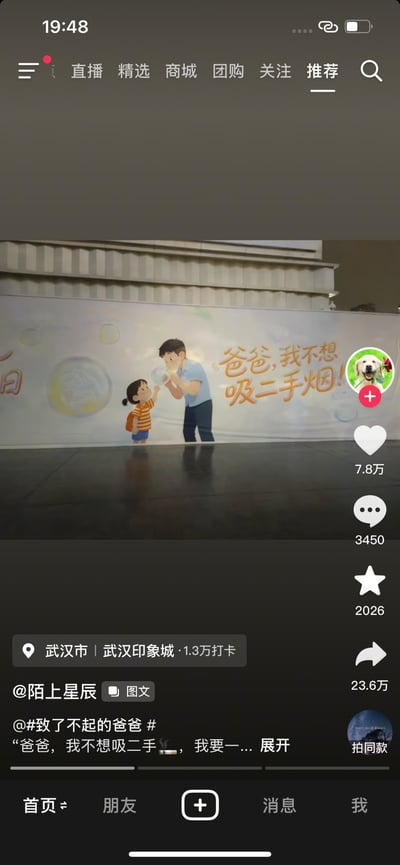 这是一张抖音移动端界面的截图，拍摄定位为武汉印象城，核心内容是该商圈设置的禁烟主题公益墙绘：墙绘左侧是背着橙色书包、穿橙白条纹上衣的小女孩，抬手指向面前的成年男性，右侧配文“爸爸，我不想吸二手烟！”，但墙绘中男性手放在嘴边的动作，刚好和抽烟时捂嘴的动作高度相似，形成了视觉错位，让原本正向的禁烟公益宣传呈现出反差的搞笑效果。截图同时保留了抖音的交互界面元素，显示该内容获7.8万点赞、3450条评论、2026次收藏、23.6万次转发，发布账号为@陌上星辰，关联话题为#致了不起的爸爸#，文案部分提到“爸爸，我不想吸二手烟”相关内容。