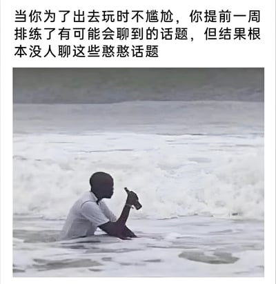 图片上方配有文字：'当你为了出去玩时不尴尬，你提前一周排练了有可能会聊到的话题，但结果根本没人聊这些憨憨话题'。下方是一张真人照片，画面中一人独坐于浅水区，手持瓶子，背景是起伏的波浪，人物背对镜头望向远方，整体氛围落寞，形象地表达了精心准备的社交话题未被使用的无奈与尴尬。