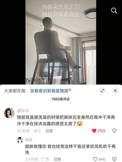 这是一张社交媒体内容截图，上方的配图中一名男子背对着镜头，坐在放置于桌面的椅子上眺望窗外，配文“当你突然意识到独居意味着自由”，原本意在展现独居生活无拘无束的惬意感；下方是该内容的评论区，两条高赞评论故意发布违背常识、极度荒诞的恶搞发言，第一条用户称独居时洗澡会把屎抹满全身再冲干净涂沐浴露，第二条用户接梗表示自己也有同类行为，还会先用吹风机吹干再洗，用离谱到反常的内容和上方“独居自由”的温馨氛围形成强烈反差，制造出滑稽的搞笑效果。