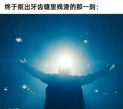 图片上方配有文字“终于抠出牙齿缝里残渣的那一刻：”，下方是一张戏剧化场景截图：一名人物背对镜头，双臂向两侧张开，面向中央的耀眼光源，周围有漂浮的光斑，整体营造出一种如释重负、获得解脱的夸张氛围。通过将日常小事与电影中常见的“获得救赎”式高光时刻结合，形成幽默的反差效果，调侃人们抠出牙缝残渣时的极度舒适与满足感。